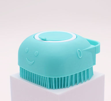 Blue silicone bath brush with smiling face design and soft bristles on a white pedestal