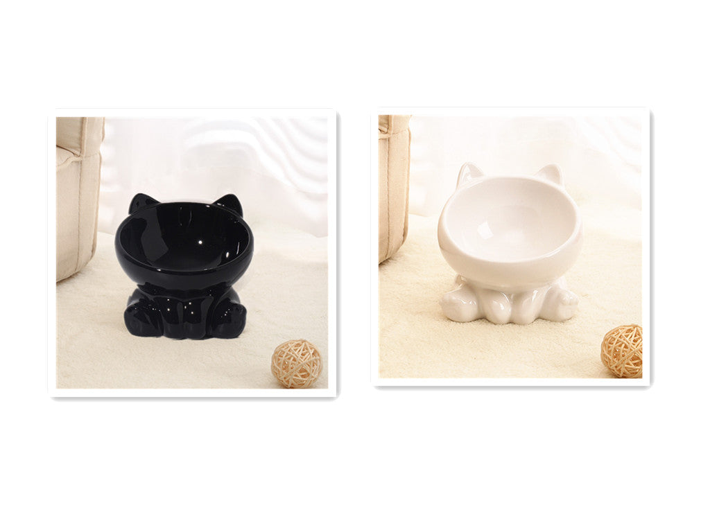 Black and white ceramic cat-shaped bowls on cream carpet, decorative pet feeders