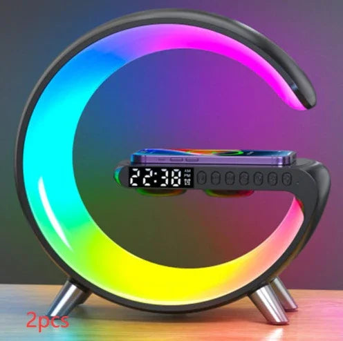 Modern LED alarm clock with wireless phone charging and colorful circular light, on a desk